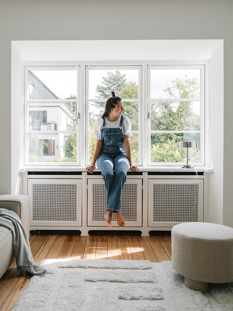 Eine Frau sitzt auf einem Fenstersims