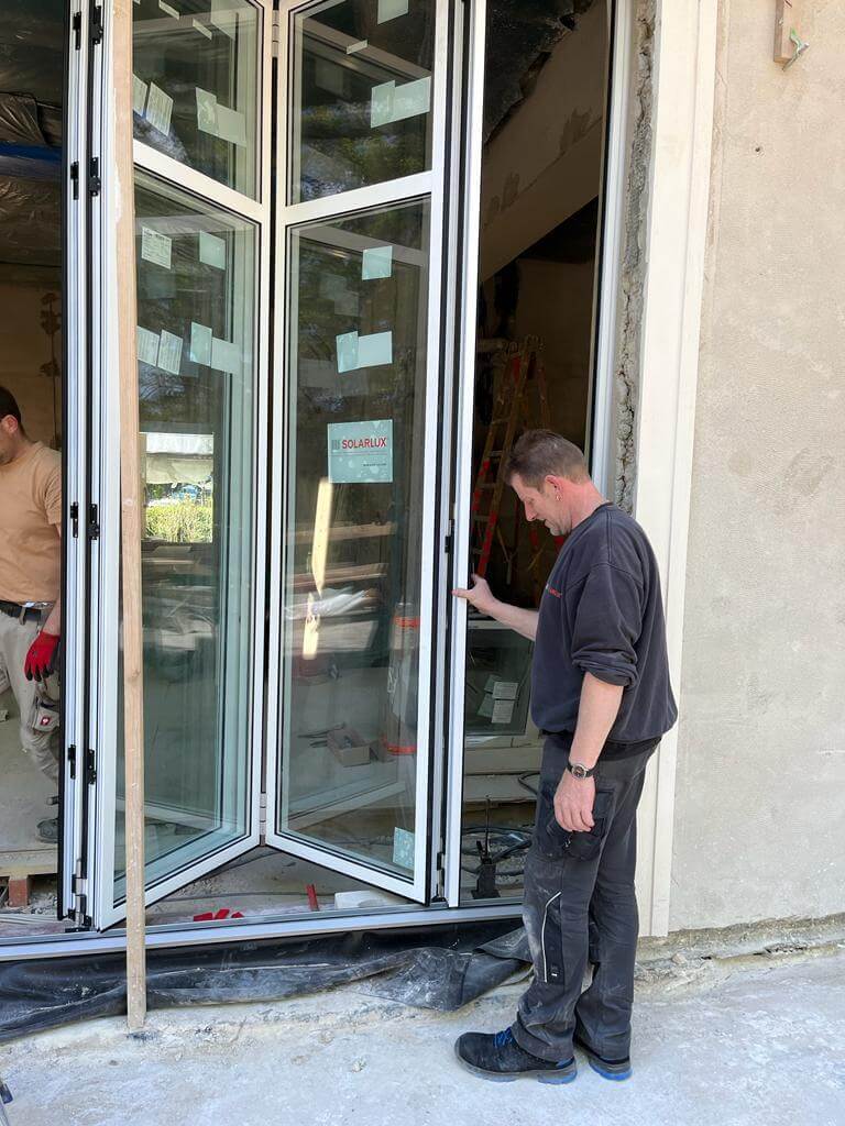 Fensterbauer beim Einbau von Faltschiebetüren aus Glas