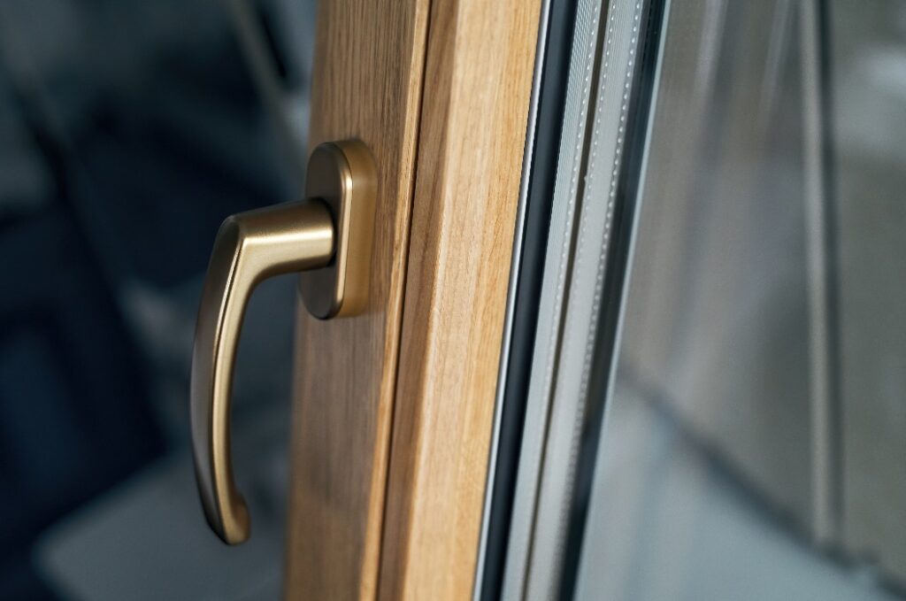 stilvoller Griff am Fensterrahmen in Goldfarbe.