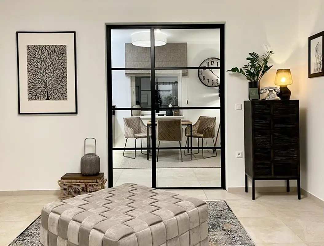 Modernes Wohnzimmer in Beige mit Pouf, Glaswand und Pflanzen, ruhig
